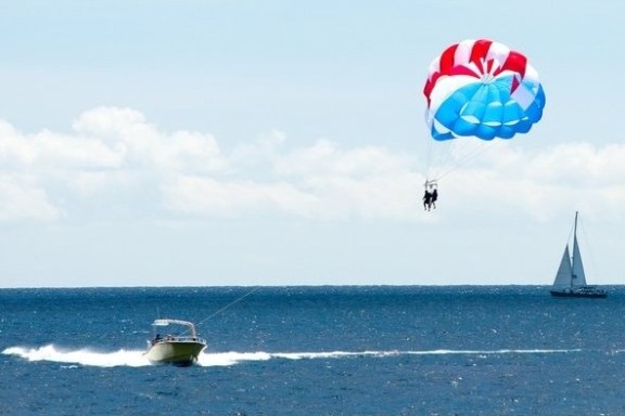 a person flying a kite in a boat on a body of water