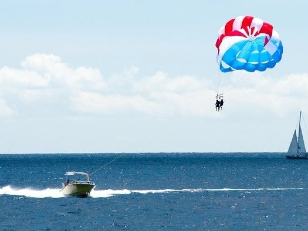 a man flying a kite in a boat on a body of water